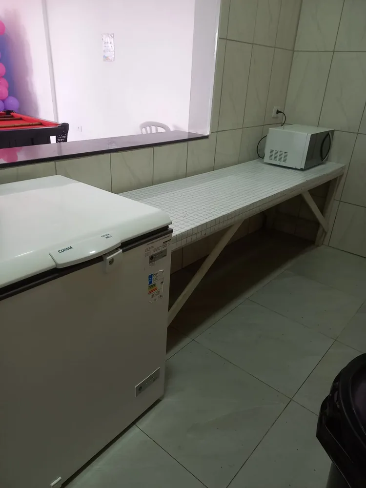 Bancada com micro-ondas, freezer e passa-pratos para o salão