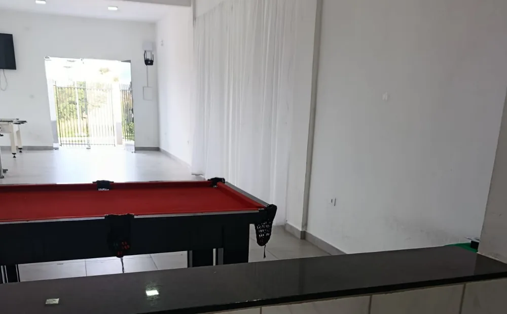 Passa-pratos da cozinha com vista para o salão e a mesa de sinuca